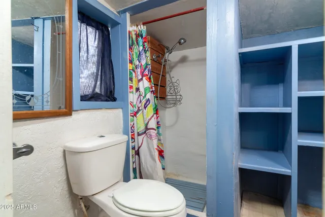 a white toilet sitting next to a bathroom sink and a tub