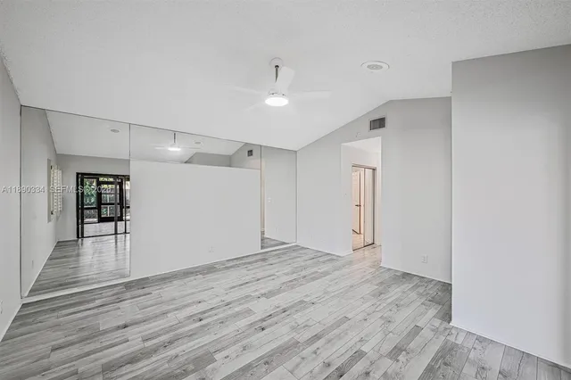 a view of empty room with wooden floor