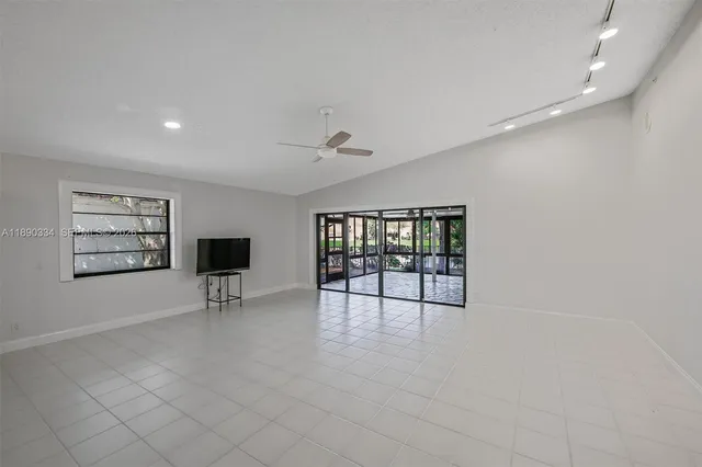 an empty room with windows and fireplace