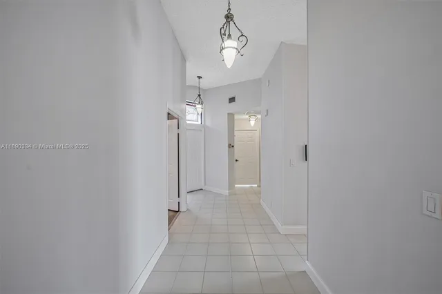 a view of a hallway with a chandelier fan