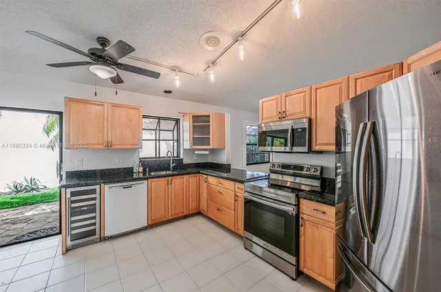 a kitchen with stainless steel appliances granite countertop a stove a sink and a refrigerator