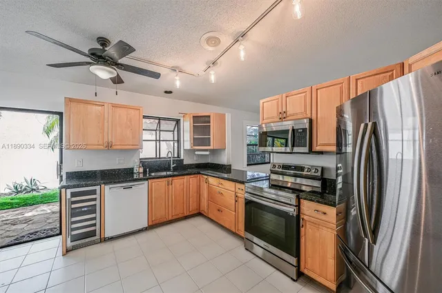 a kitchen with stainless steel appliances granite countertop a stove a sink and a refrigerator