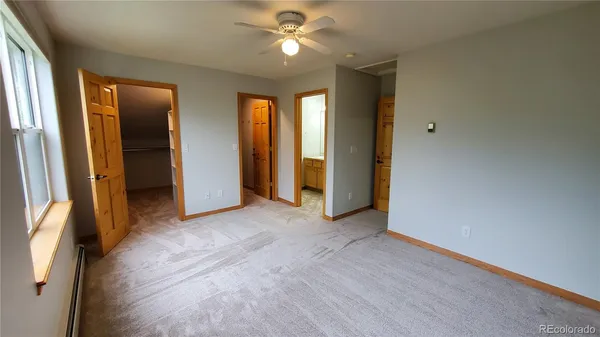 an empty room with closet and a chandelier fan