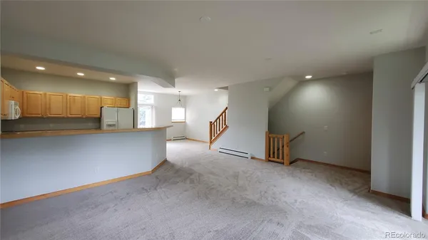 a view of an empty room with a kitchen