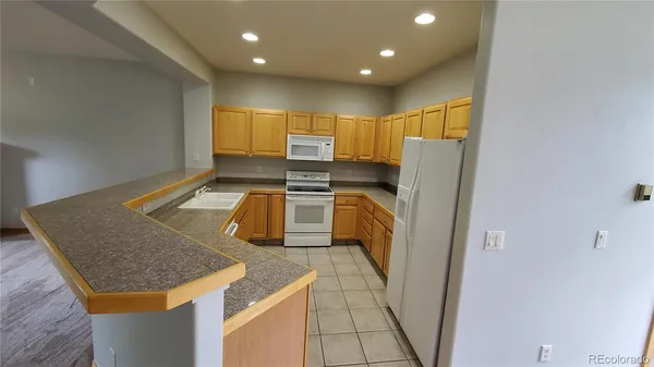 a kitchen with stainless steel appliances granite countertop refrigerator sink and stove