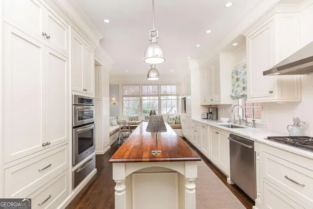 a kitchen with stainless steel appliances granite countertop a sink a stove and a wooden floors