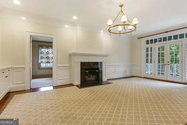 a view of an empty room with a fireplace and a chandelier