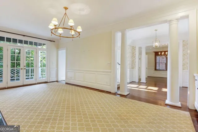 a view of a hallway with wooden floor and a kitchen