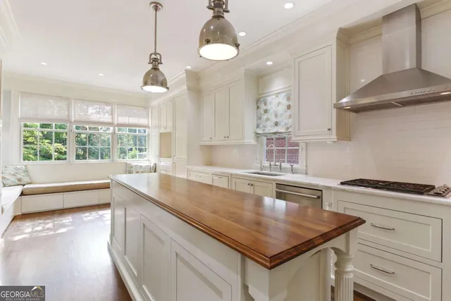 a kitchen with white cabinets and sink