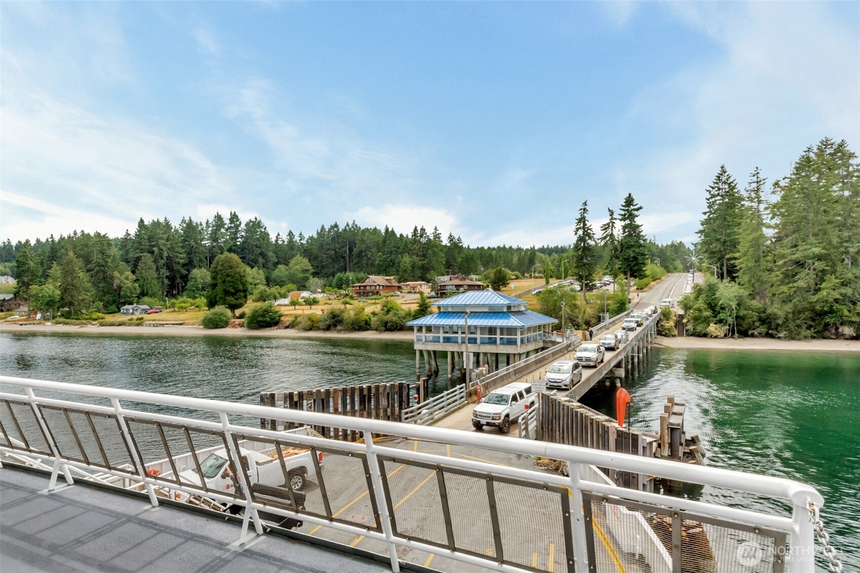 10115 Edgewood Drive Anderson Island, WA 98303 - Photo 10 of 16 a view of a wooden deck and lake with trees in the background