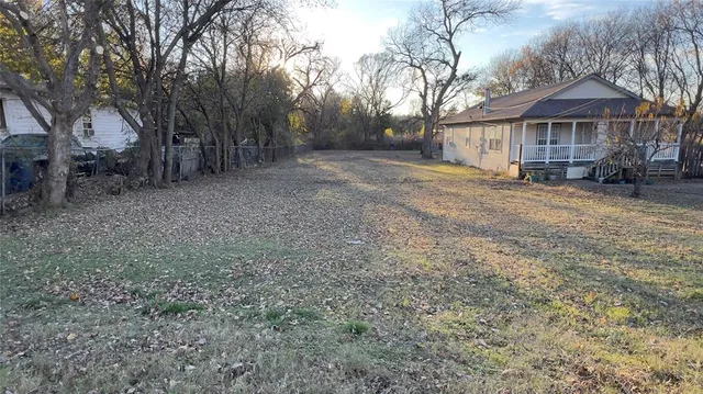 a view of a house with a yard covered in the forest
