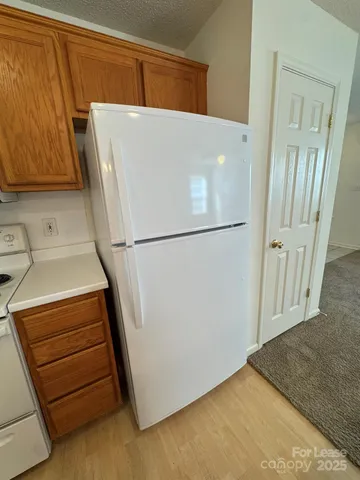 a white refrigerator freezer and a stove sitting inside of a kitchen
