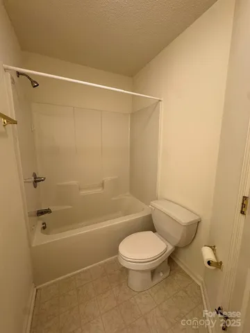 a white toilet and tub next to a bathroom sink