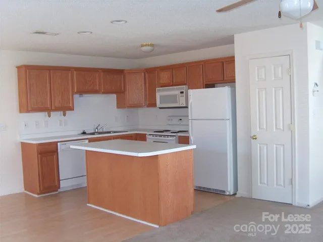 a kitchen with stainless steel appliances granite countertop a refrigerator a sink and a stove