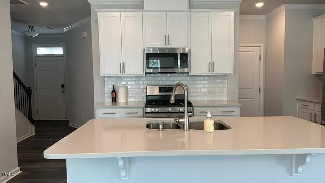 a kitchen with kitchen island a sink a stove and a refrigerator