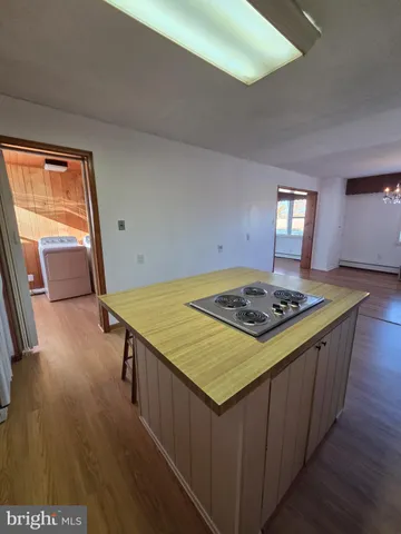 a kitchen that has a stove and a wooden floor