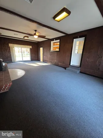 a view of an empty room with a window and fireplace