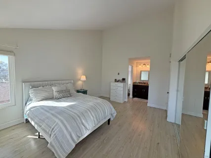 a bedroom with a bed and a refrigerator