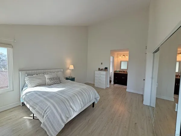 a bedroom with a bed and a refrigerator