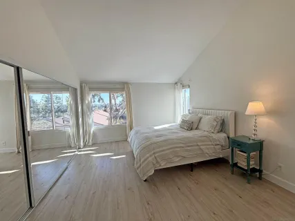 a bedroom with a bed and a lamp next to a window