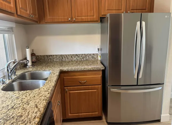 a kitchen with a refrigerator sink and cabinets