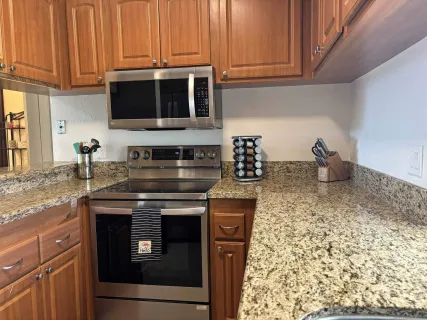 a kitchen with stainless steel appliances granite countertop a stove and a microwave