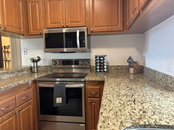 a kitchen with stainless steel appliances granite countertop a stove and a microwave