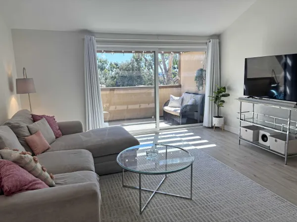 a living room with furniture a flat screen tv and a large window
