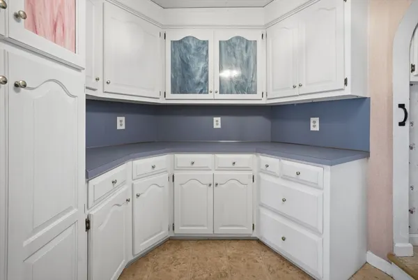 a kitchen with white cabinets and sink