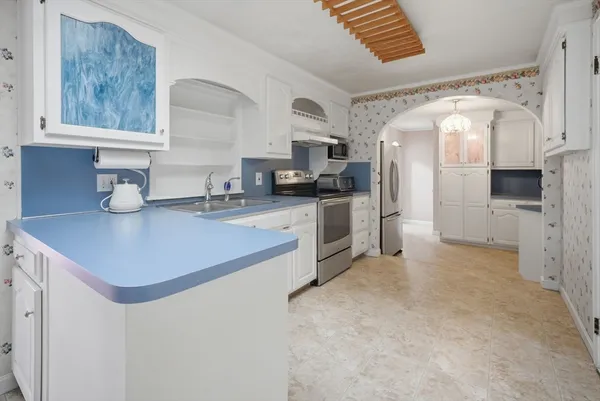 a kitchen with stainless steel appliances a sink a stove a refrigerator cabinets and a counter top space