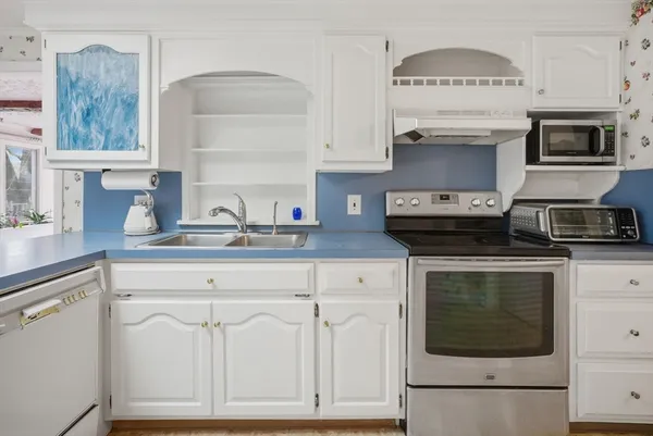 a kitchen with stainless steel appliances granite countertop a stove a sink and a microwave
