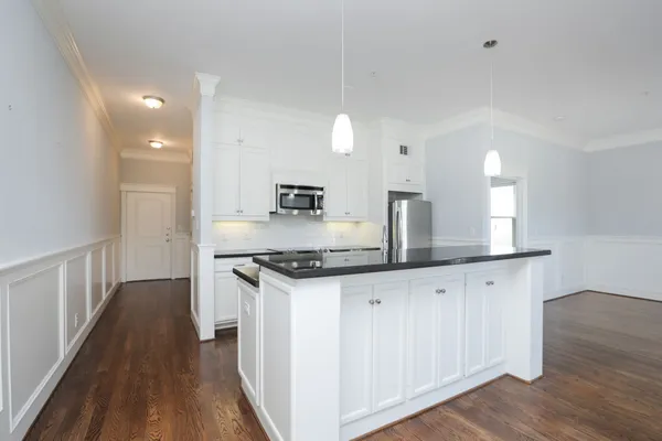 a kitchen with granite countertop a sink stainless steel appliances and white cabinets