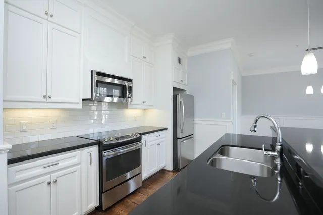 a kitchen with stainless steel appliances granite countertop a sink stove and microwave
