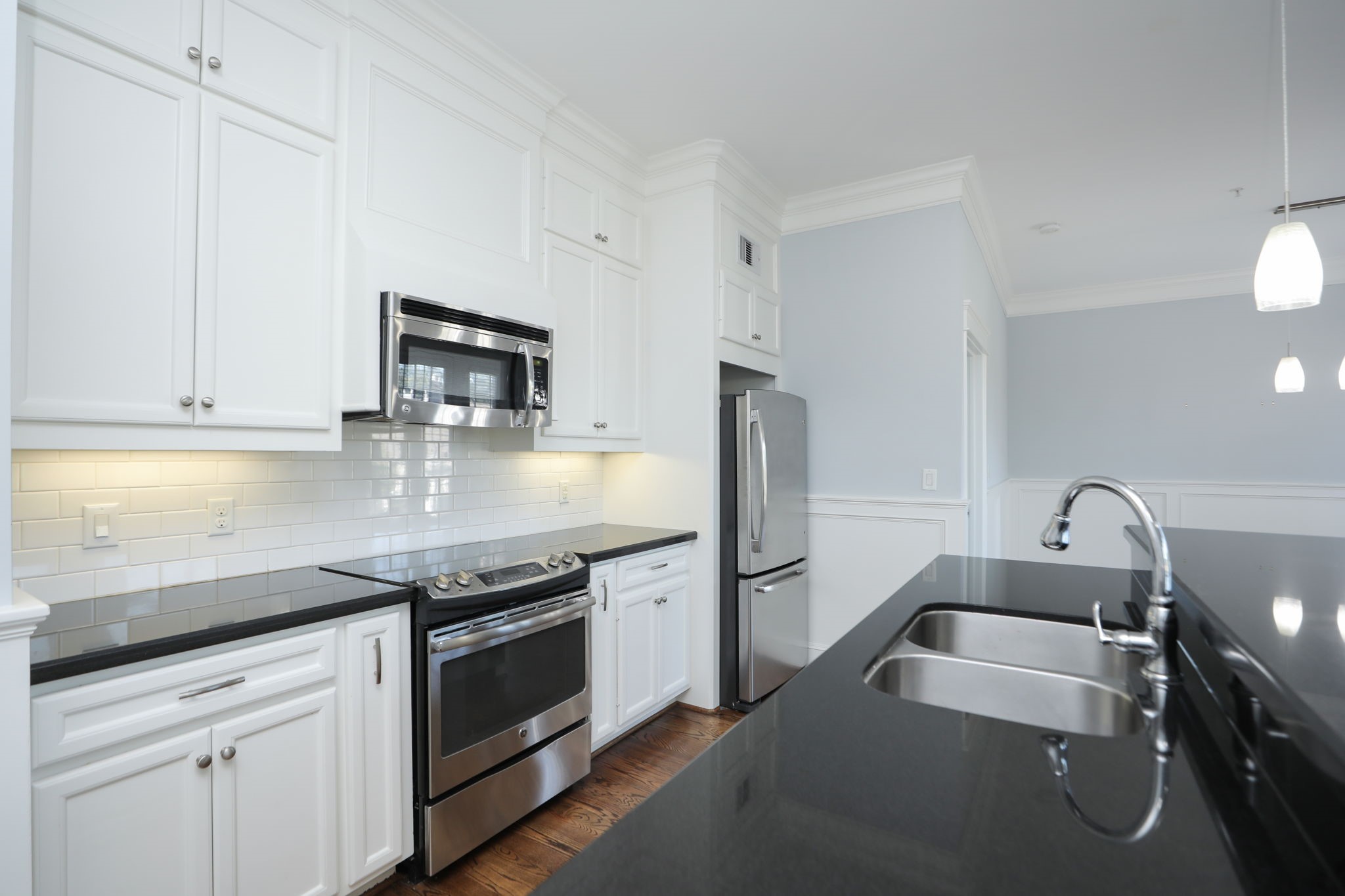 2802 Morrison Street, Unit 201 Houston, TX 77009 - Photo 14 of 50 a kitchen with granite countertop a sink stainless steel appliances and white cabinets