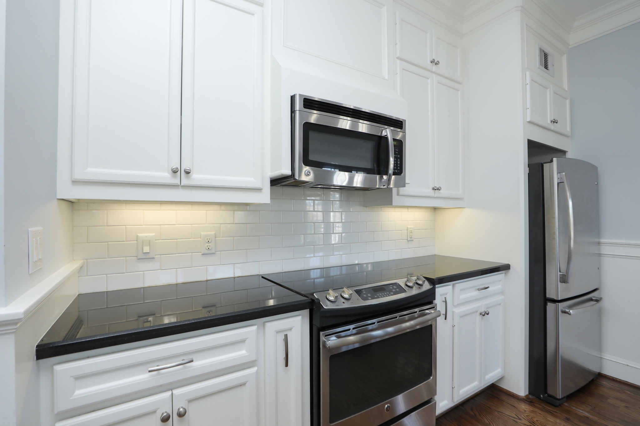 2802 Morrison Street, Unit 201 Houston, TX 77009 - Photo 17 of 50 a kitchen with granite countertop a stove and a microwave