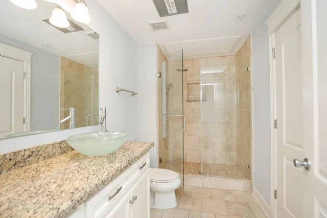a bathroom with a granite countertop sink a mirror and wooden floor