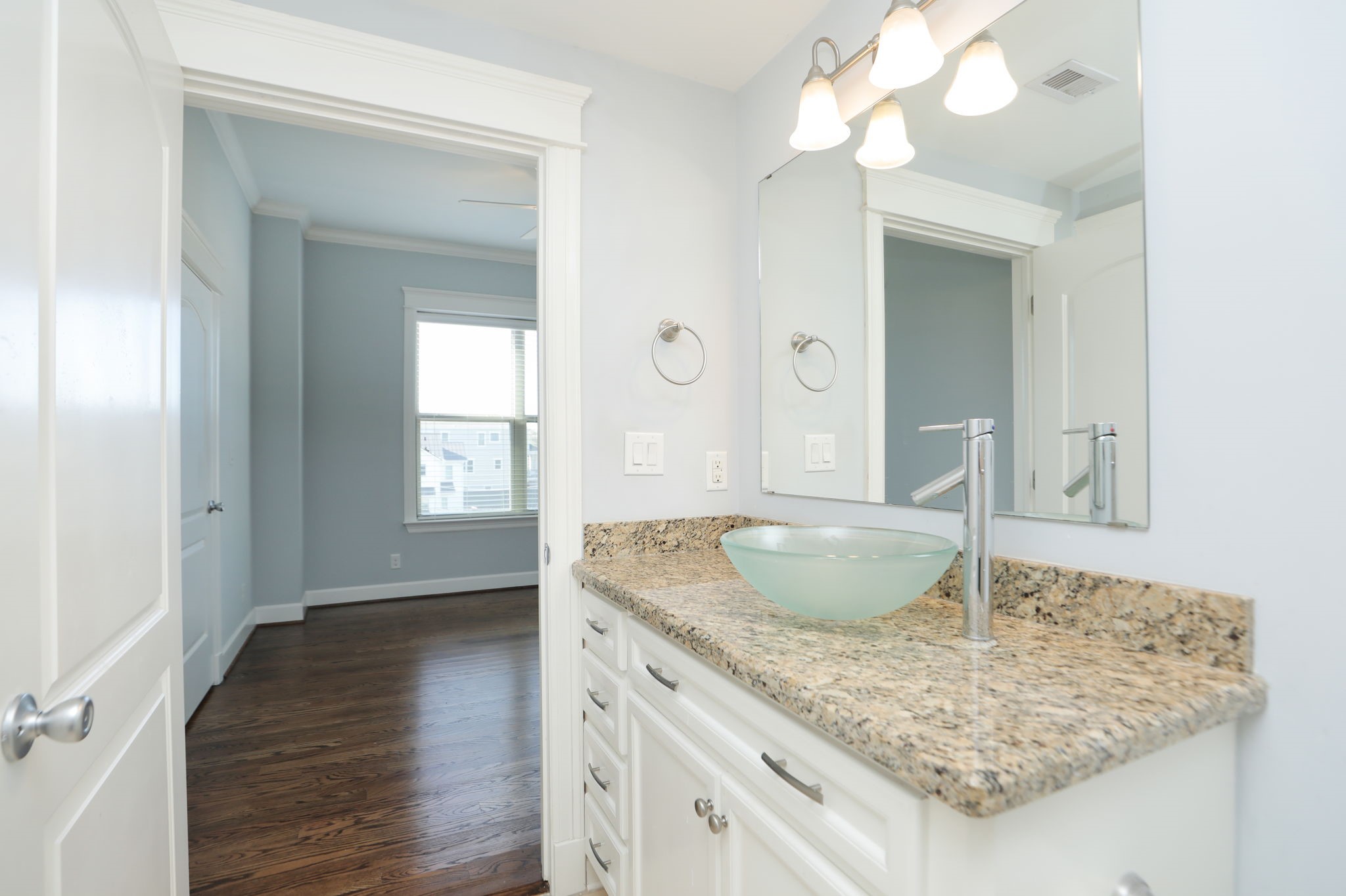 2802 Morrison Street, Unit 201 Houston, TX 77009 - Photo 33 of 50 a bathroom with a granite countertop sink a mirror and wooden floor