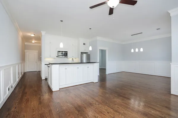 a kitchen with granite countertop a sink cabinets and wooden floor