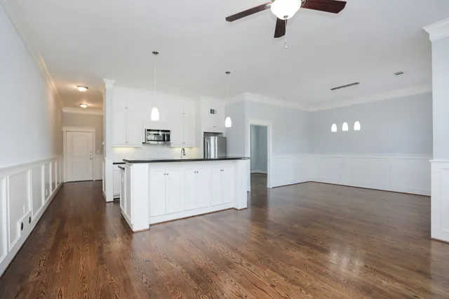 a kitchen with granite countertop a sink cabinets and wooden floor