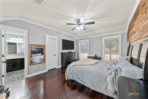 a bedroom with a large bed a flat tv screen and a fireplace