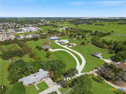 an aerial view of residential houses with outdoor space and ocean view