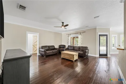 a living room with furniture and wooden floor