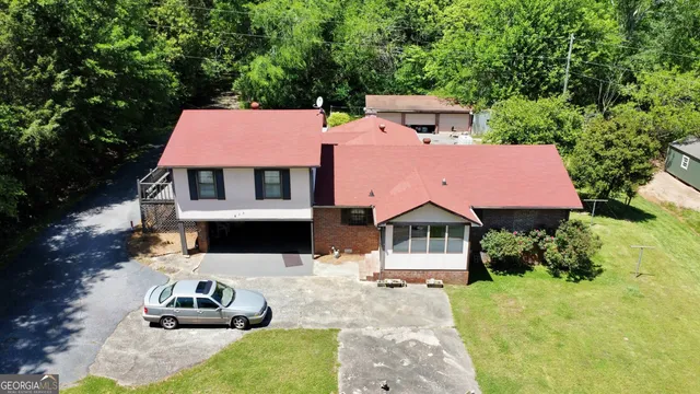a front view of a house with a garden and parking