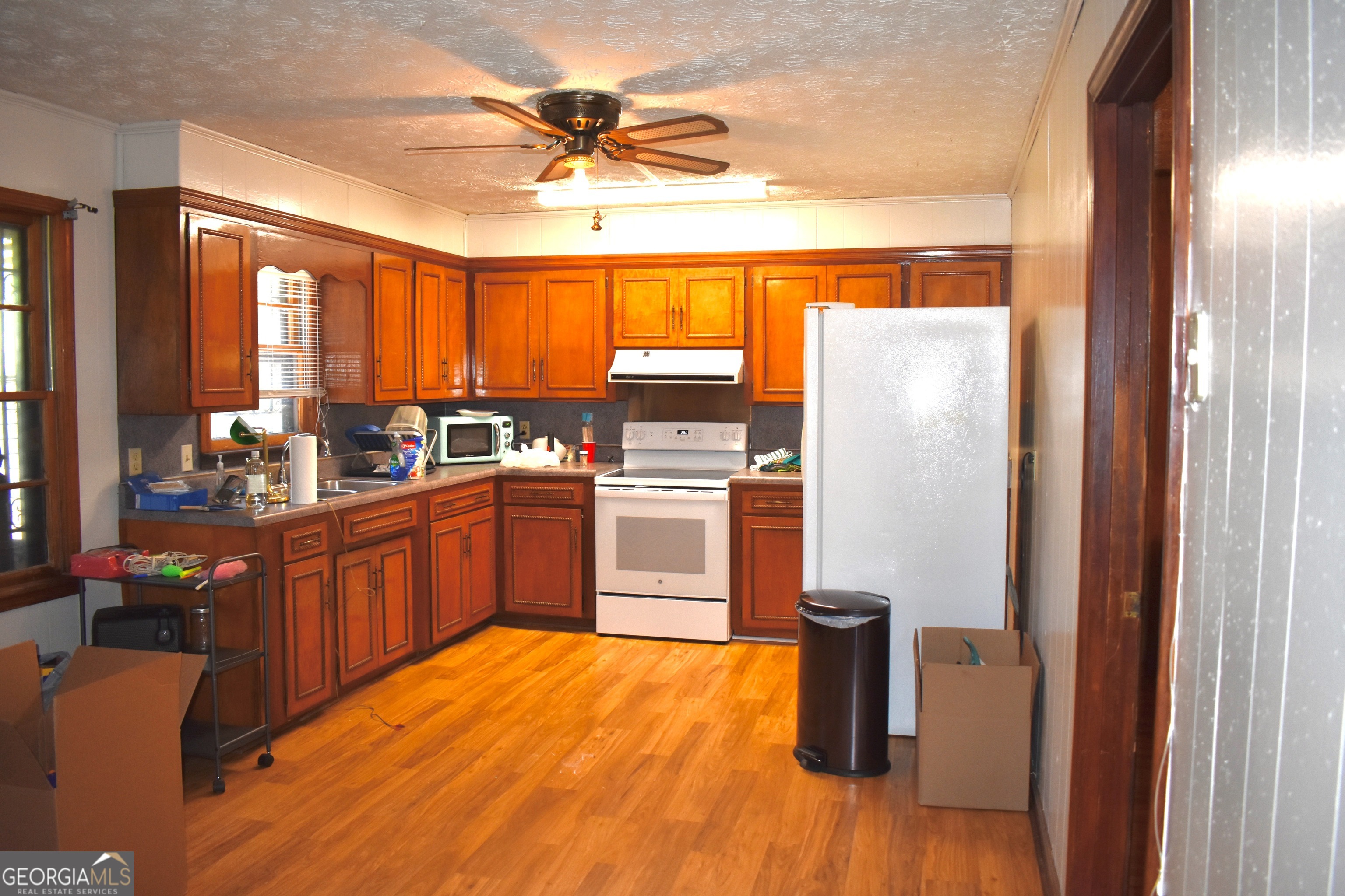 148 Upson Street Lexington, GA 30648 - Photo 4 of 12 a kitchen with stainless steel appliances a stove a refrigerator and a sink with wooden floor