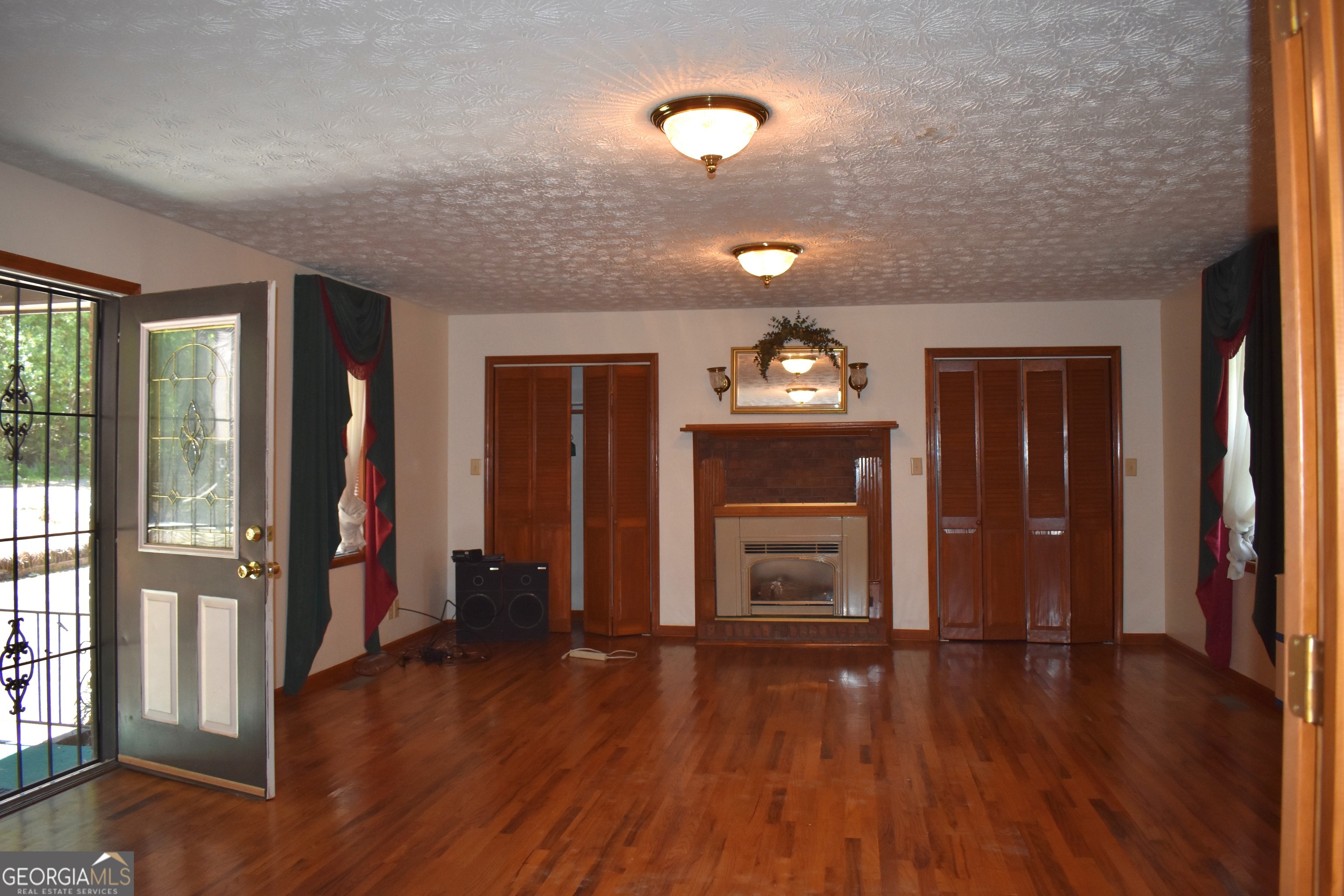 148 Upson Street Lexington, GA 30648 - Photo 9 of 12 an empty room with wooden floor and windows