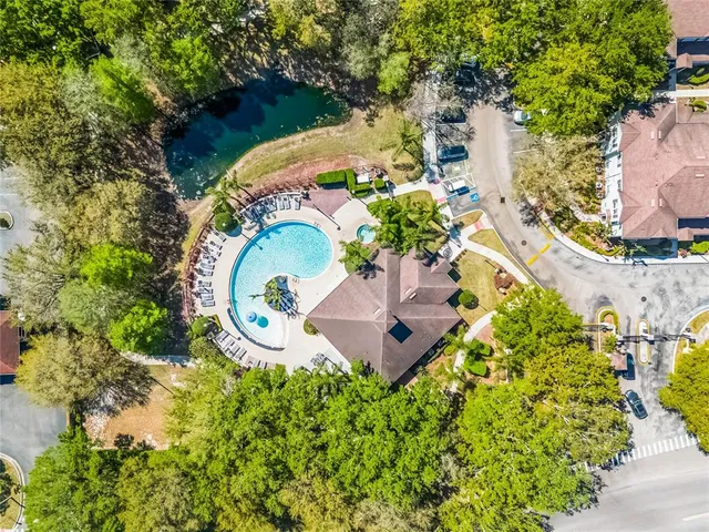 an aerial view of a house with a swimming pool a yard and a garden