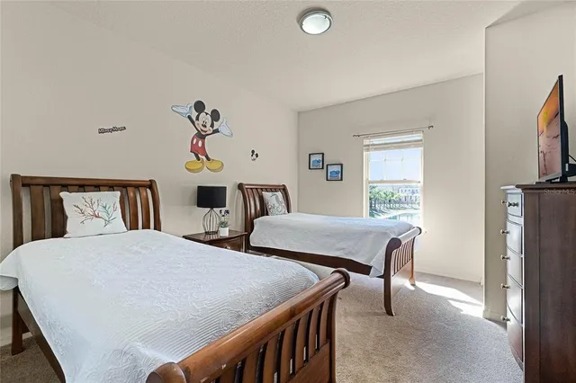 a bedroom with two beds and a desk