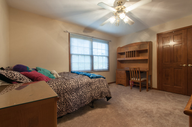 3087 Wagner Road Aurora, IL 60502 - Photo 17 of 20 a bedroom with a bed and a chandelier