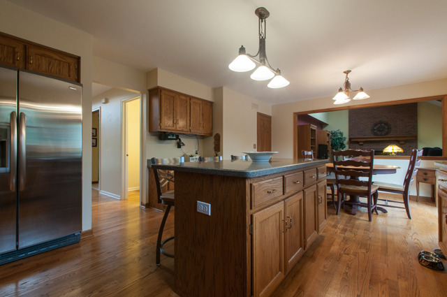 3087 Wagner Road Aurora, IL 60502 - Photo 6 of 20 a kitchen with stainless steel appliances granite countertop a refrigerator a sink dishwasher a stove and a dining table with wooden floor