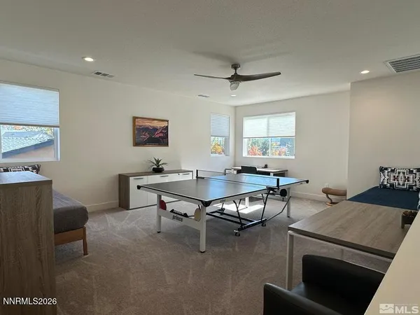 a living room with furniture a ceiling fan and a window